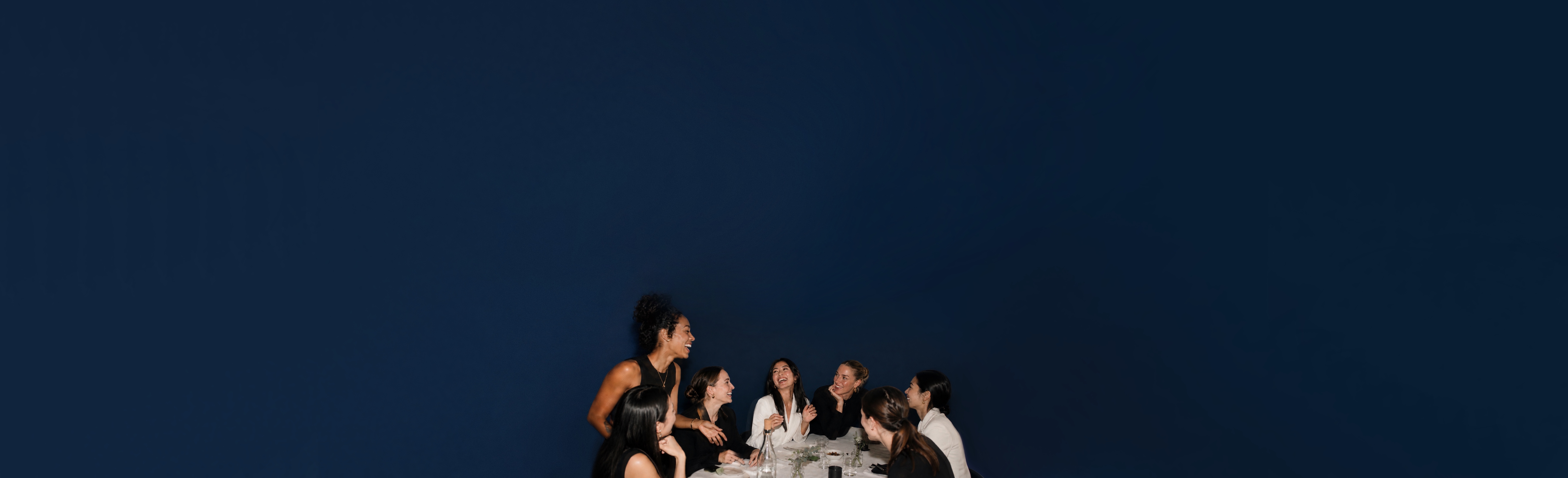 Members of Global Female Club laughing together around a dinner table